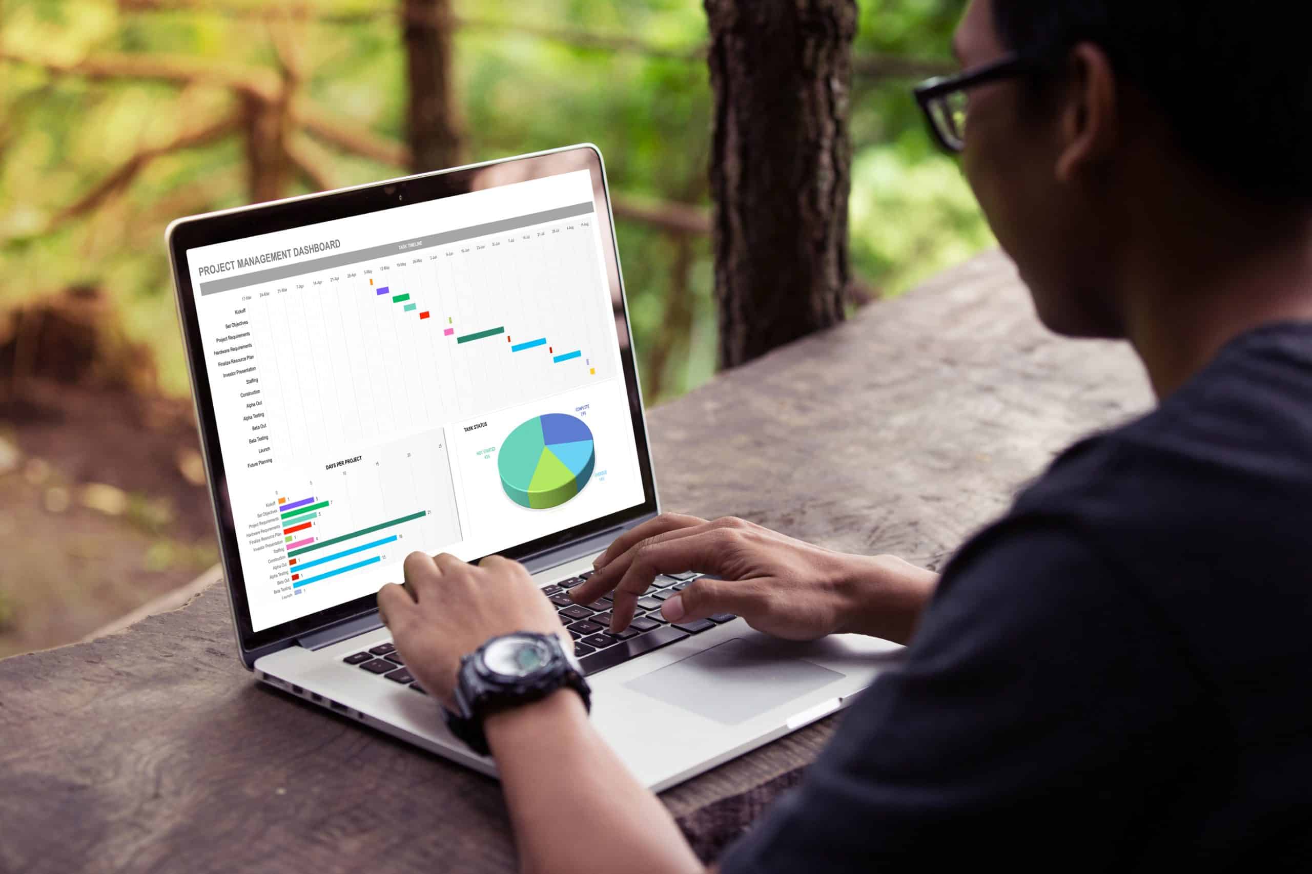 Man working with excel project dashboard on laptop outdoor