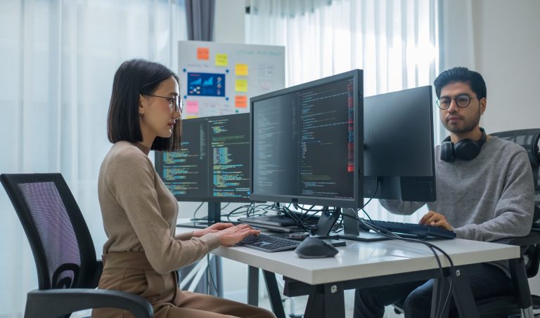 Two people coding on their computers
